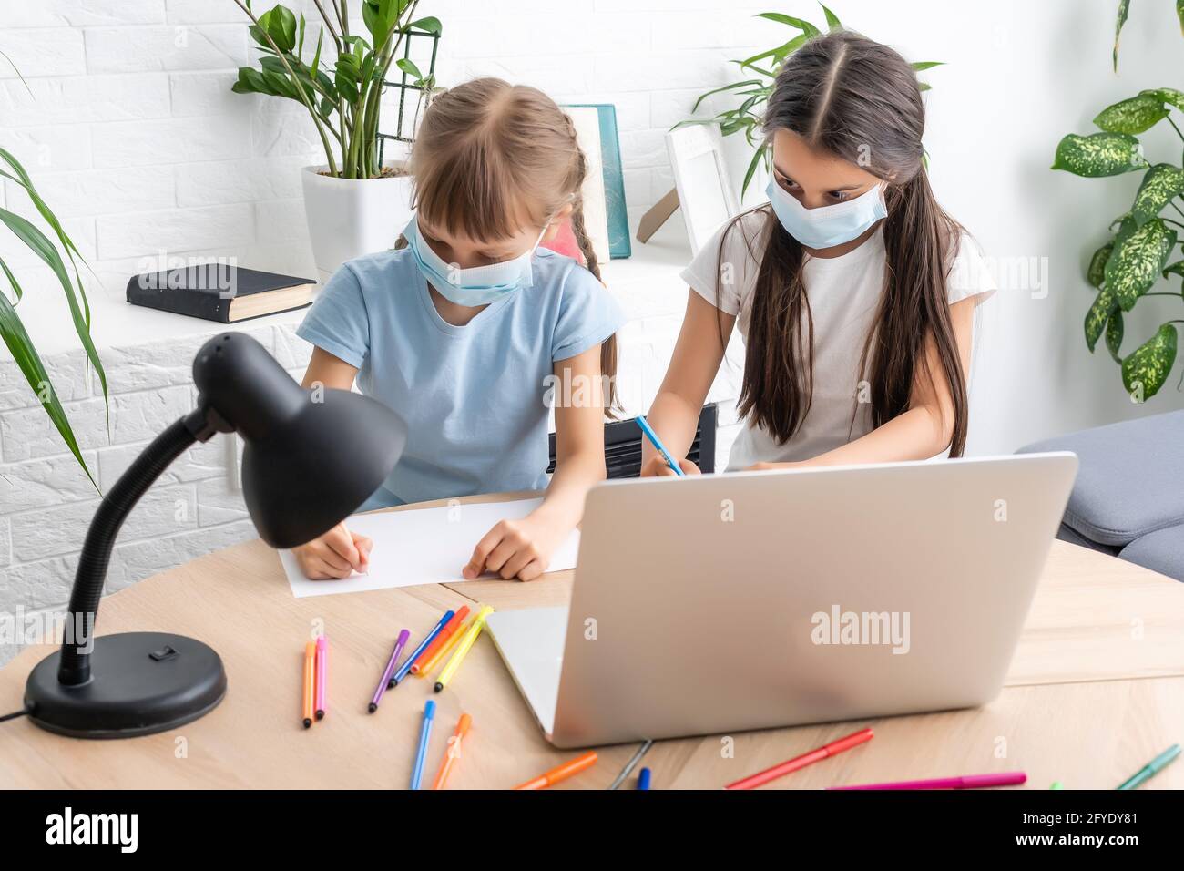 Distance learning online education. A school girls study at home and do ...