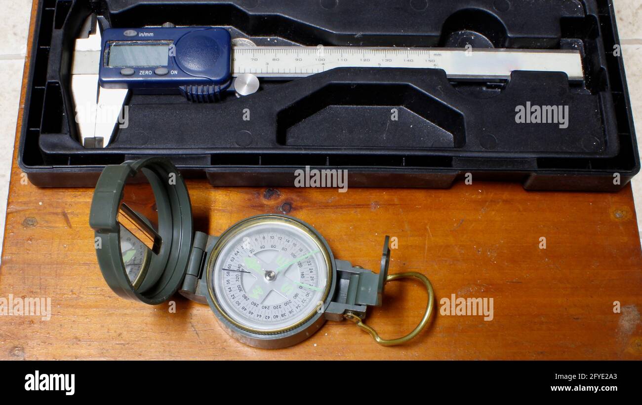 A Compass and Digital Dial Caliper on a Wood Background Stock Photo Alamy