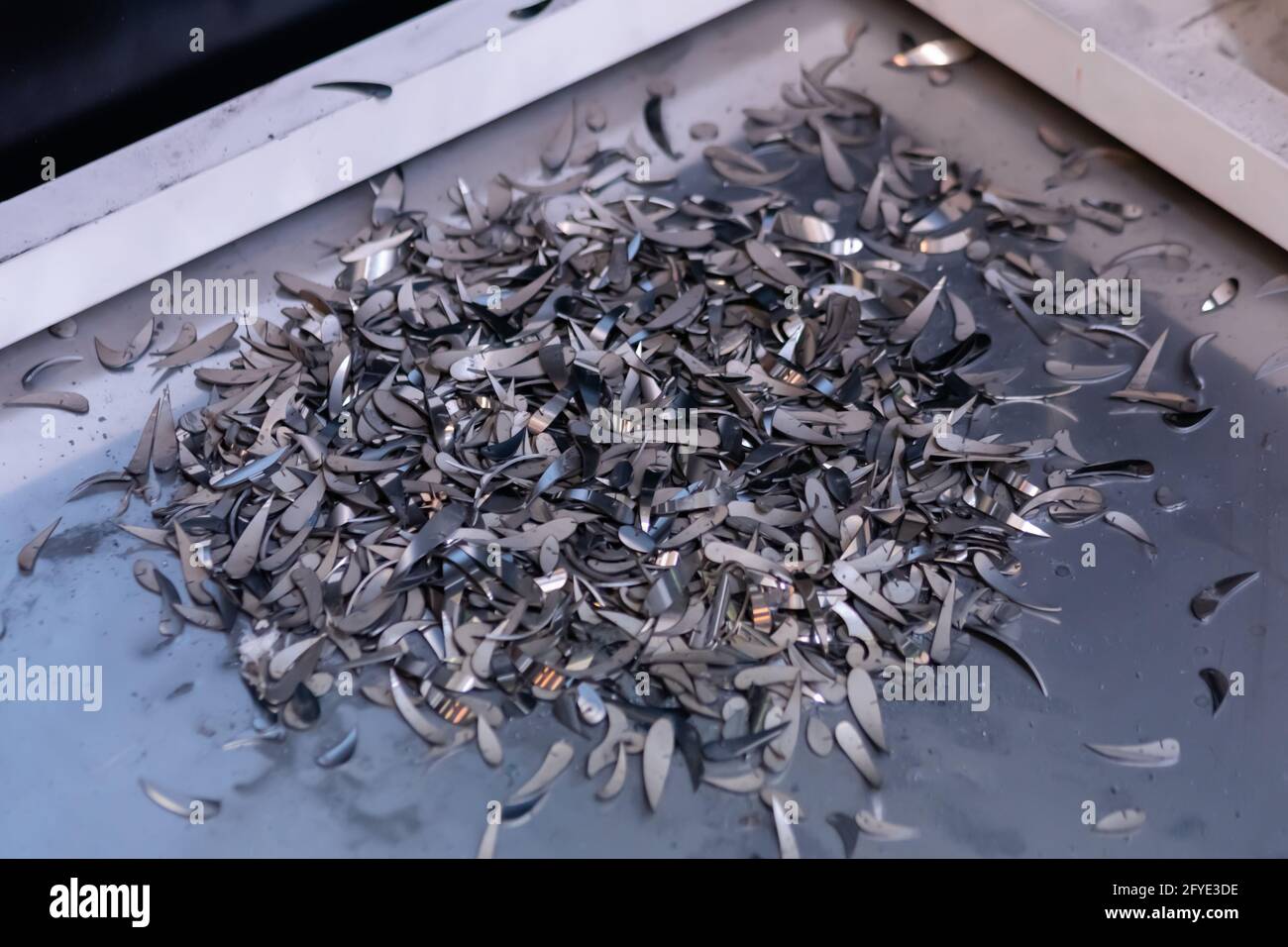 Lots of metal debris, chips, shavings after working of laser cutting machine Stock Photo