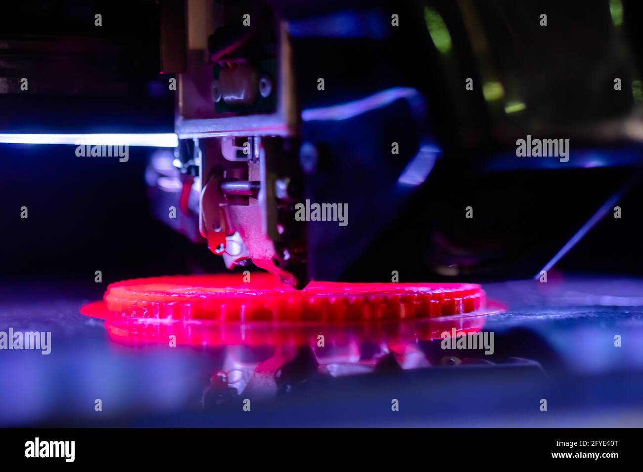 Print head of 3D printer machine printing flat plastic model - close up Stock Photo