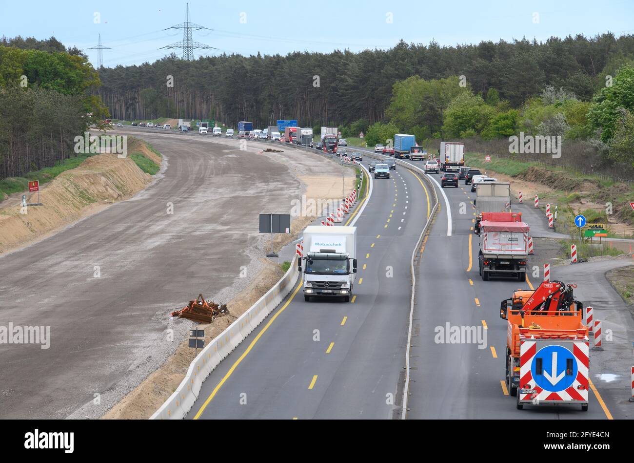 Velten, Germany. 27th May, 2021. Cars and trucks drive on the narrowed four-lane carriageway of the A10 motorway (Berliner Ring) shortly after the Oranienburg junction next to the carriageway under construction. The A10 and the A24 between the Pankow interchange and the Neuruppin junction are among the busiest routes in the capital region. They will be upgraded and renewed until 2022 while traffic continues to flow. Credit: Soeren Stache/dpa-Zentralbild/dpa/Alamy Live News Stock Photo