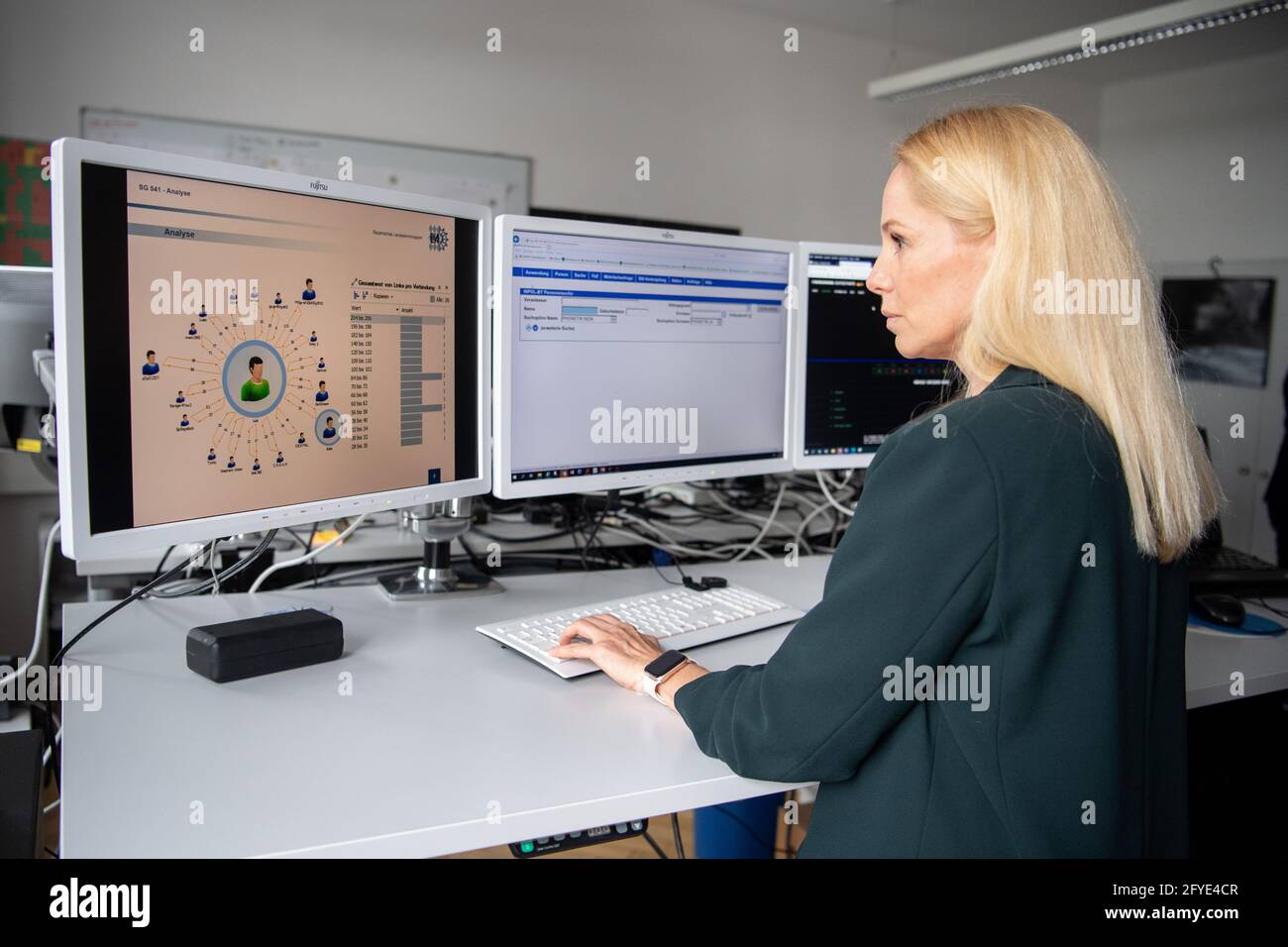12 May 2021, Bavaria, Munich: Iris Ortner, an analyst at the Bavarian State  Criminal Police Office, works at her computer during an interview  appointment for information about the police software "VeRA" at