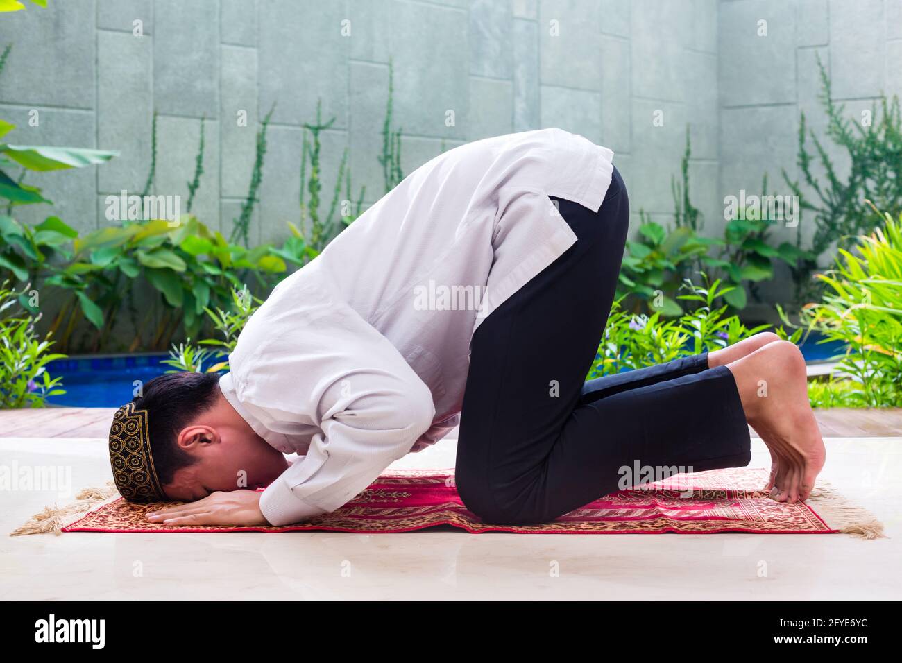 Asian Muslim man praying on carpet with beads chain wearing traditional ...