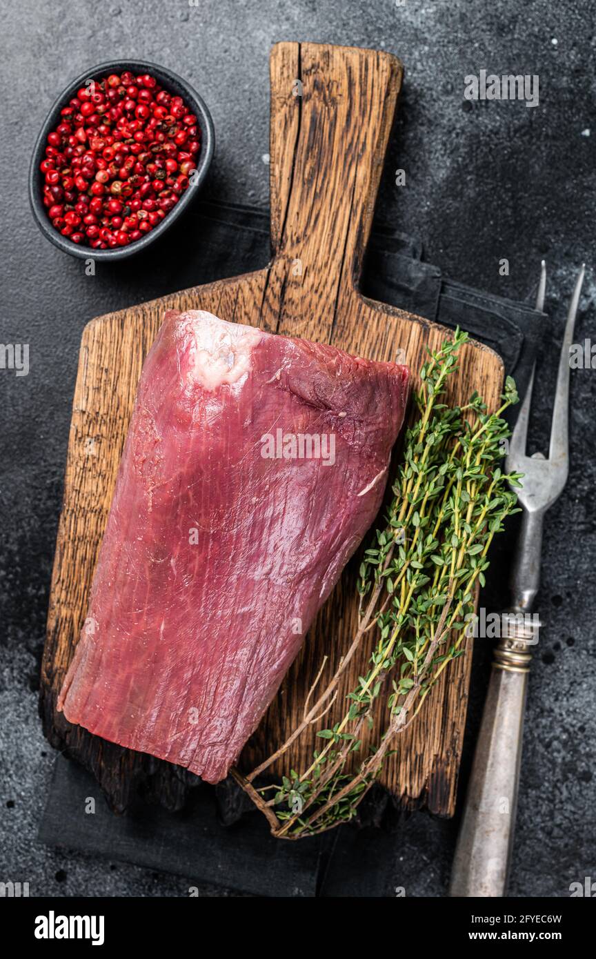 Raw Beef Tenderloin fillet meat on butcher wooden board. Black ...
