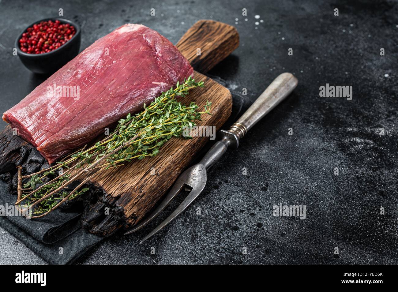 Raw Beef Tenderloin fillet meat on butcher wooden board. Black ...