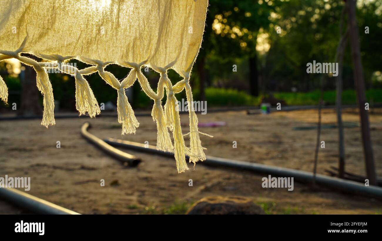 Hanging clean clothes outdoors on laundry day. Indian rural village shot. Stock Photo