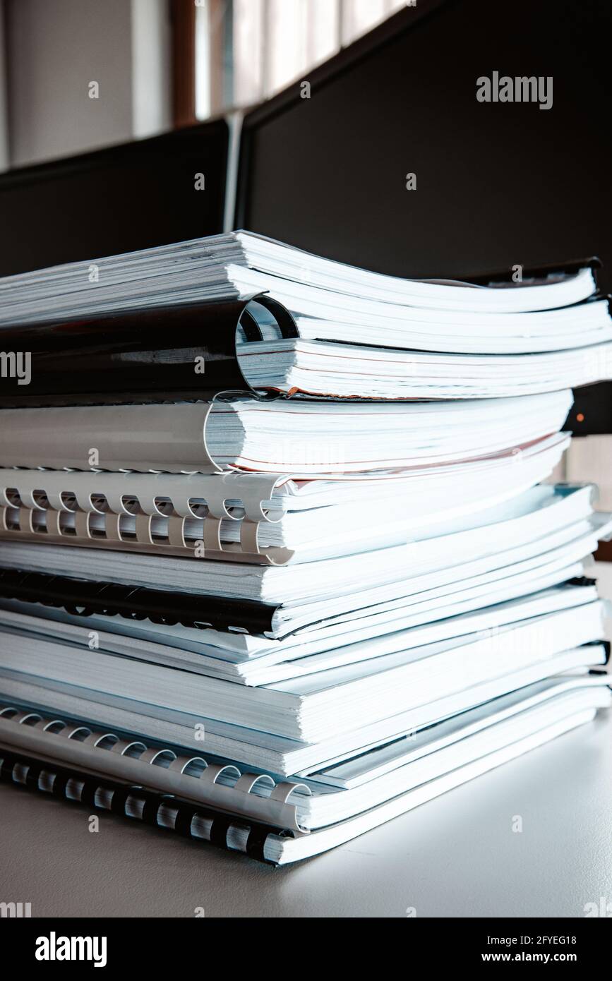 Stack of reports lies on a desk ready for review Stock Photo