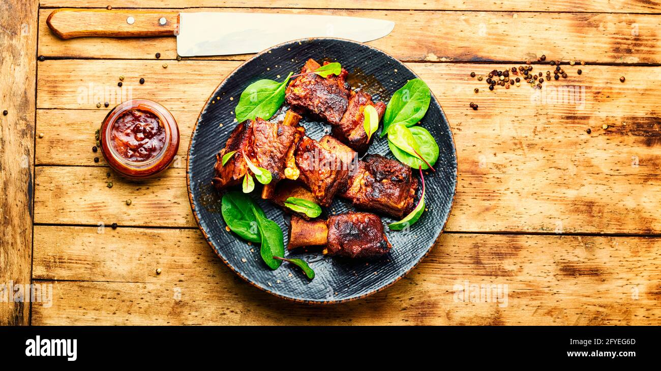 Spicy barbecue beef ribs with herb on rustic wooden table.BBQ beef rib