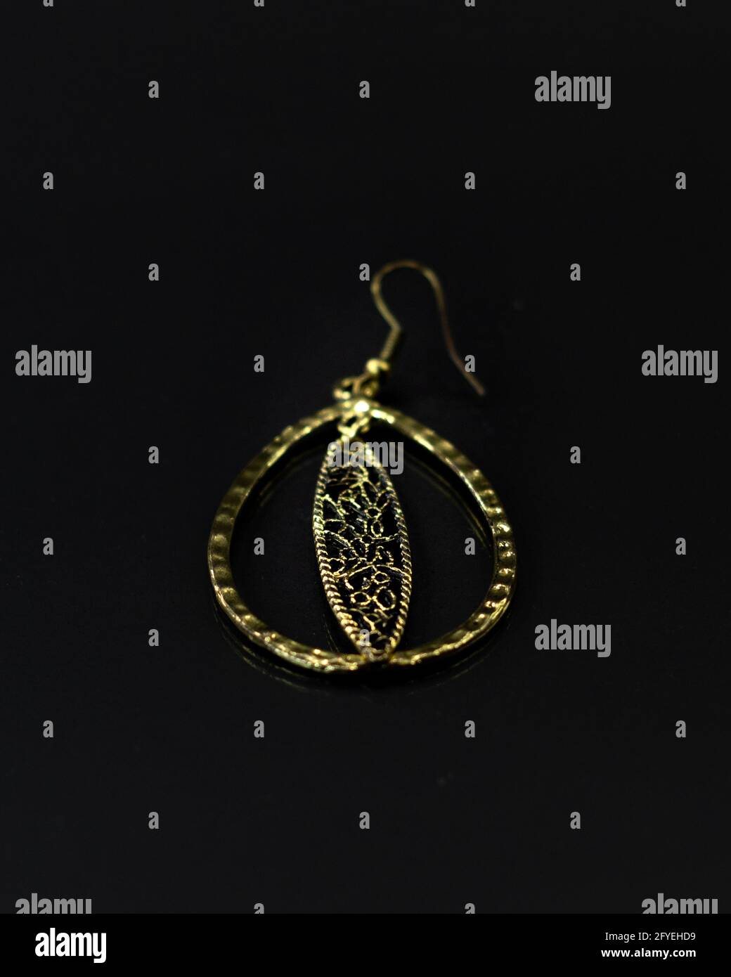 Vertical shot of the gold hoop with a black background. Stock Photo