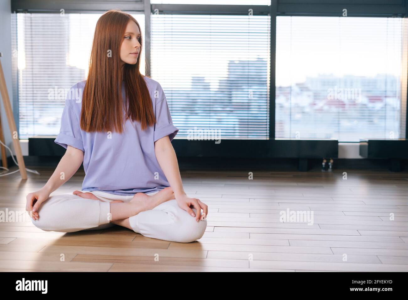Relaxed attractive young woman meditating sitting on floor in lotus ...