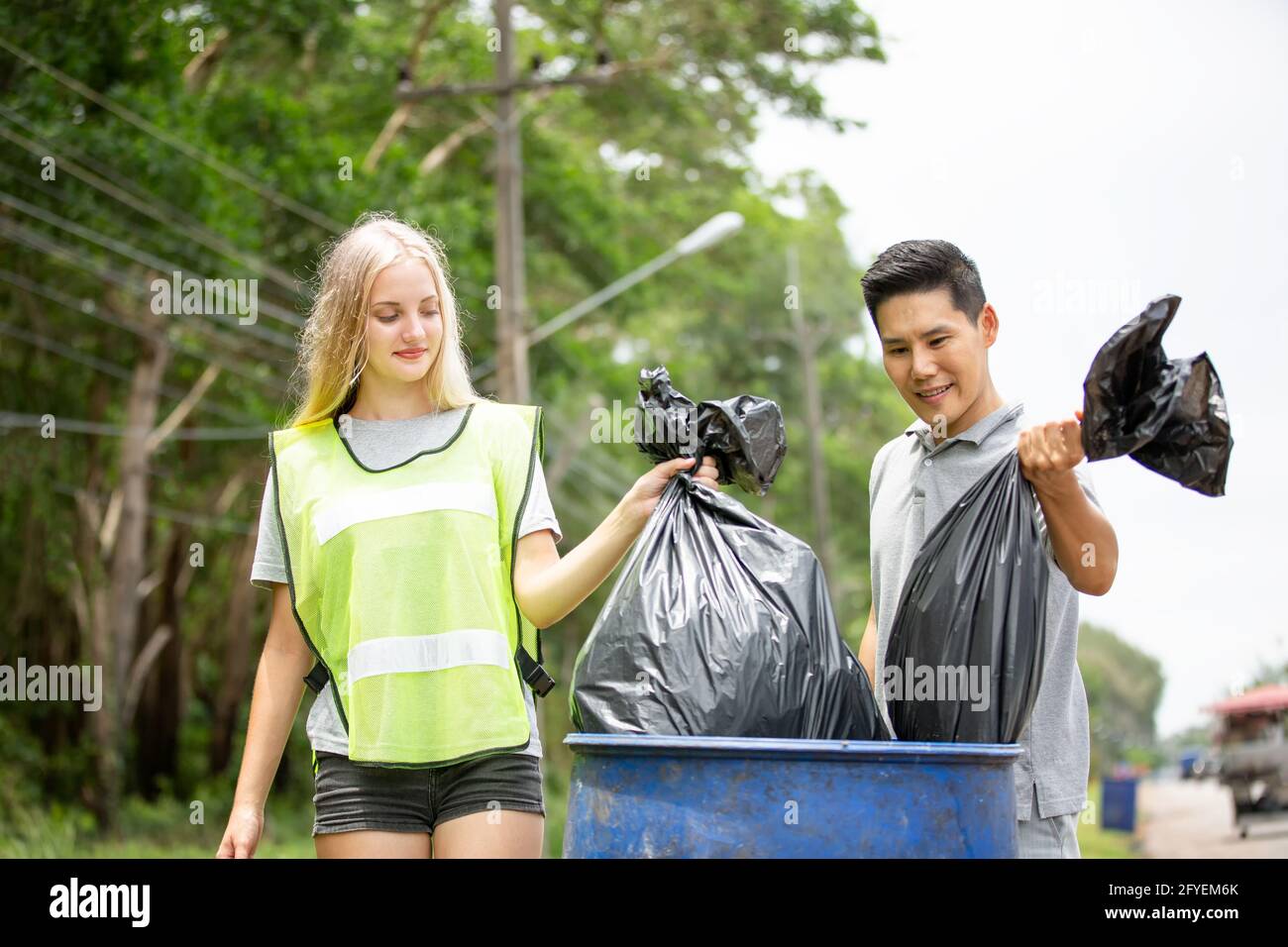 Green volunteering. Optimistic two volunteers holding garbage bag and