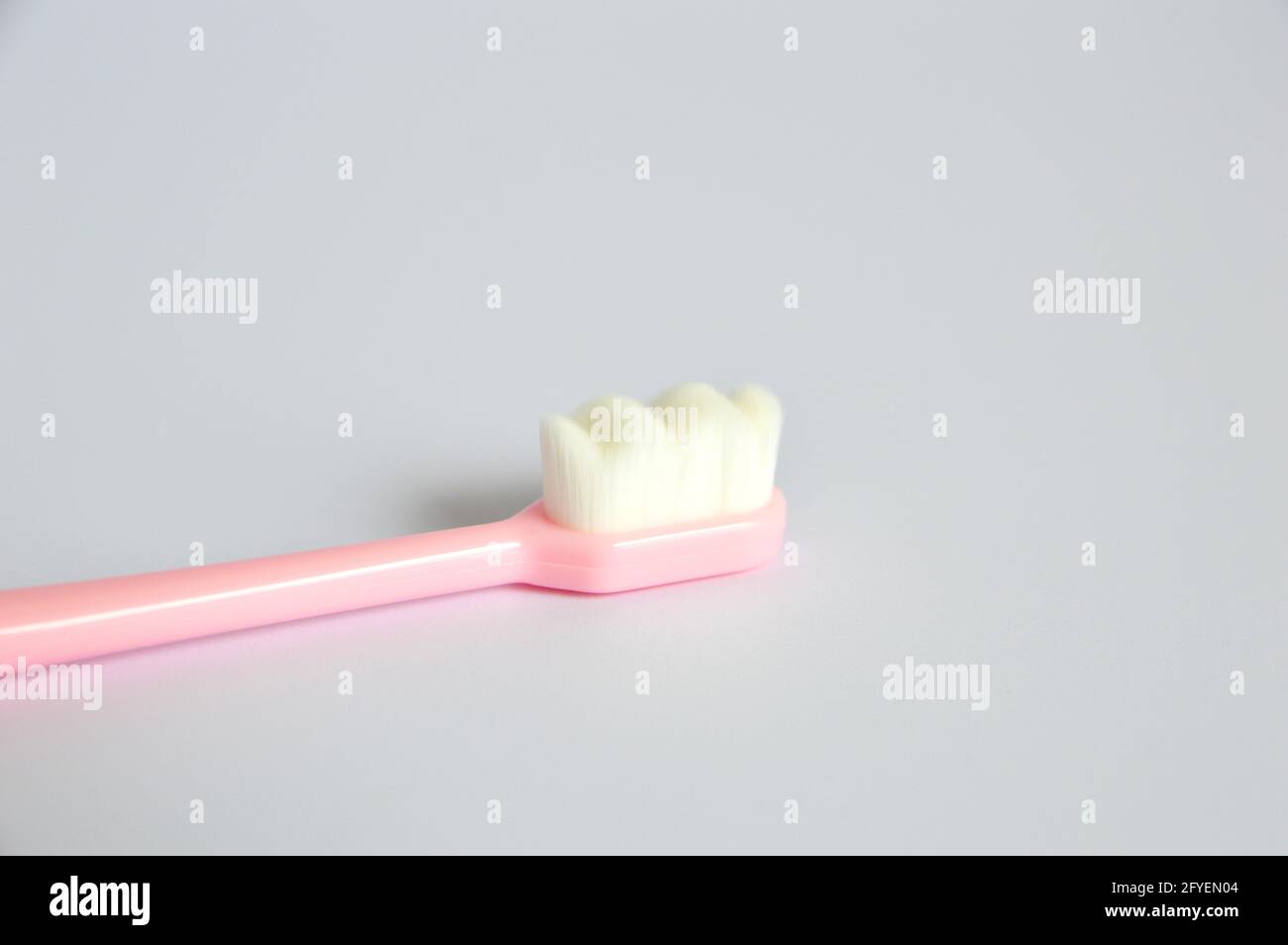 Close up photo of superfine micro-nano Japanese plastic toothbrush in gray background Stock Photo