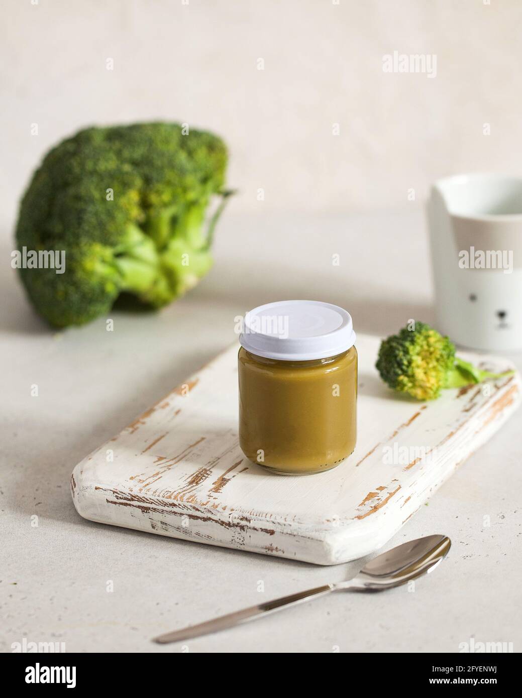 Closed glass jar with baby food broccoli smoothie on wooden board. Layout. The concept of baby food, the first feeding. Stock Photo