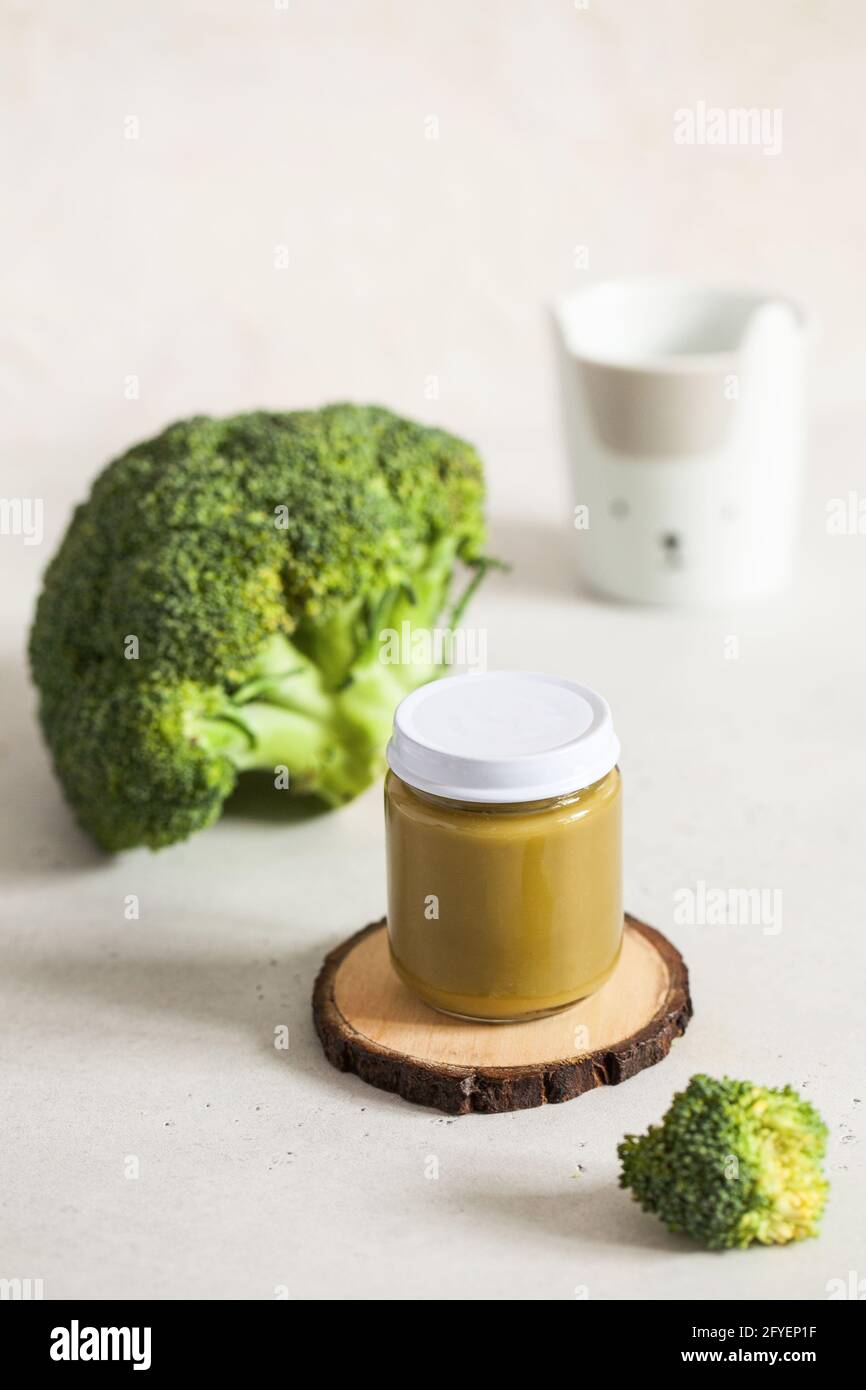 Closed glass jar with baby food broccoli smoothie with space for text. Layout Baby food concept, first feeding. Stock Photo