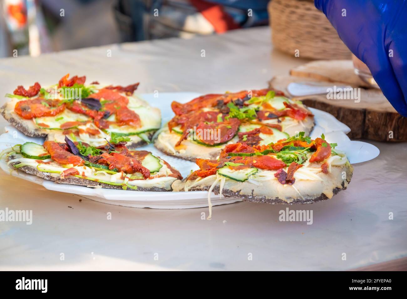 Round pizza made of black dough. Barbecue festival in the city park