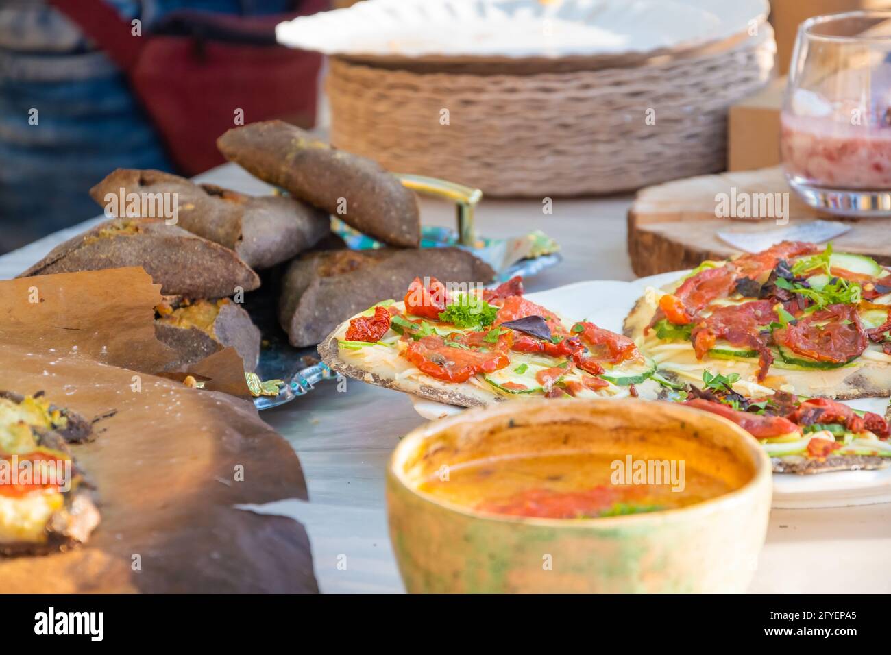 Round pizza made of black dough. Barbecue festival in the city park