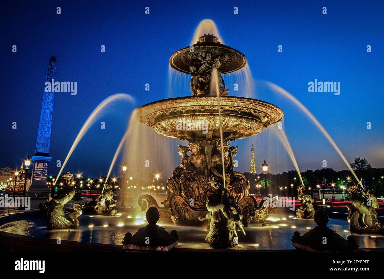 FRANCE. PARIS (75) PLACE DE LA CONCORDE. THE FOUNTAIN OF THE RIVERS AT NIGHT. THE OBELISK ILLUMINATED IN 'BLEU KLEIN', THE EIFFEL TOWER, IN THE BACKGR Stock Photo