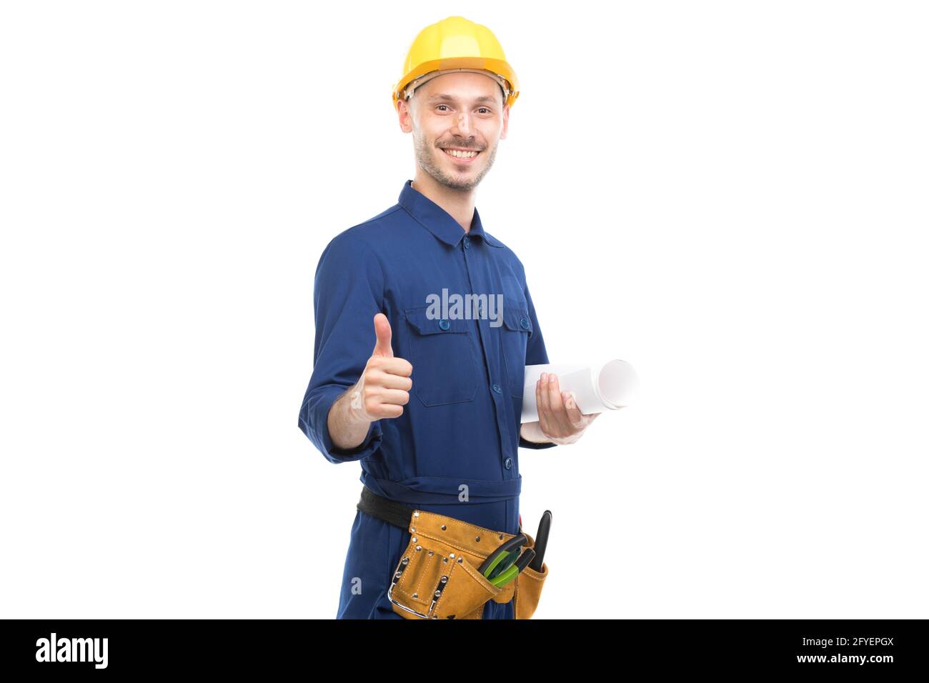 Horizontal medium portrait of confident handsome young adult Caucasian engineer wearing blue uniform holding construction plan, white background Stock Photo