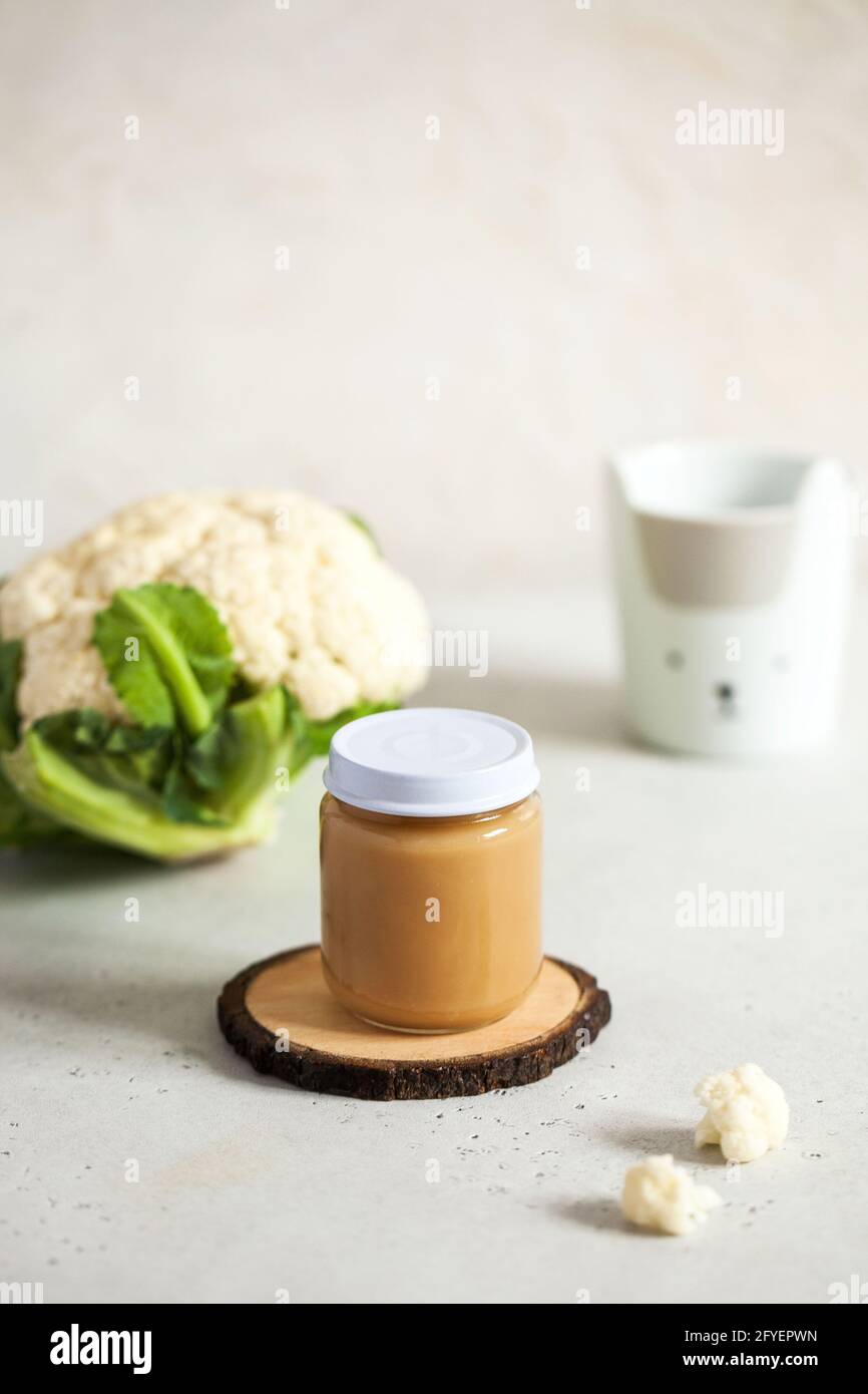 Closed glass jar with baby food cauliflower smoothie with space for text. Layout Baby food concept, first feeding. Stock Photo