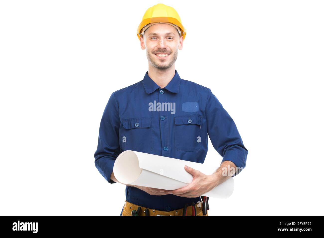 Horizontal medium portrait of modern handsome young adult Caucasian engineer wearing blue uniform holding construction plan, white background Stock Photo