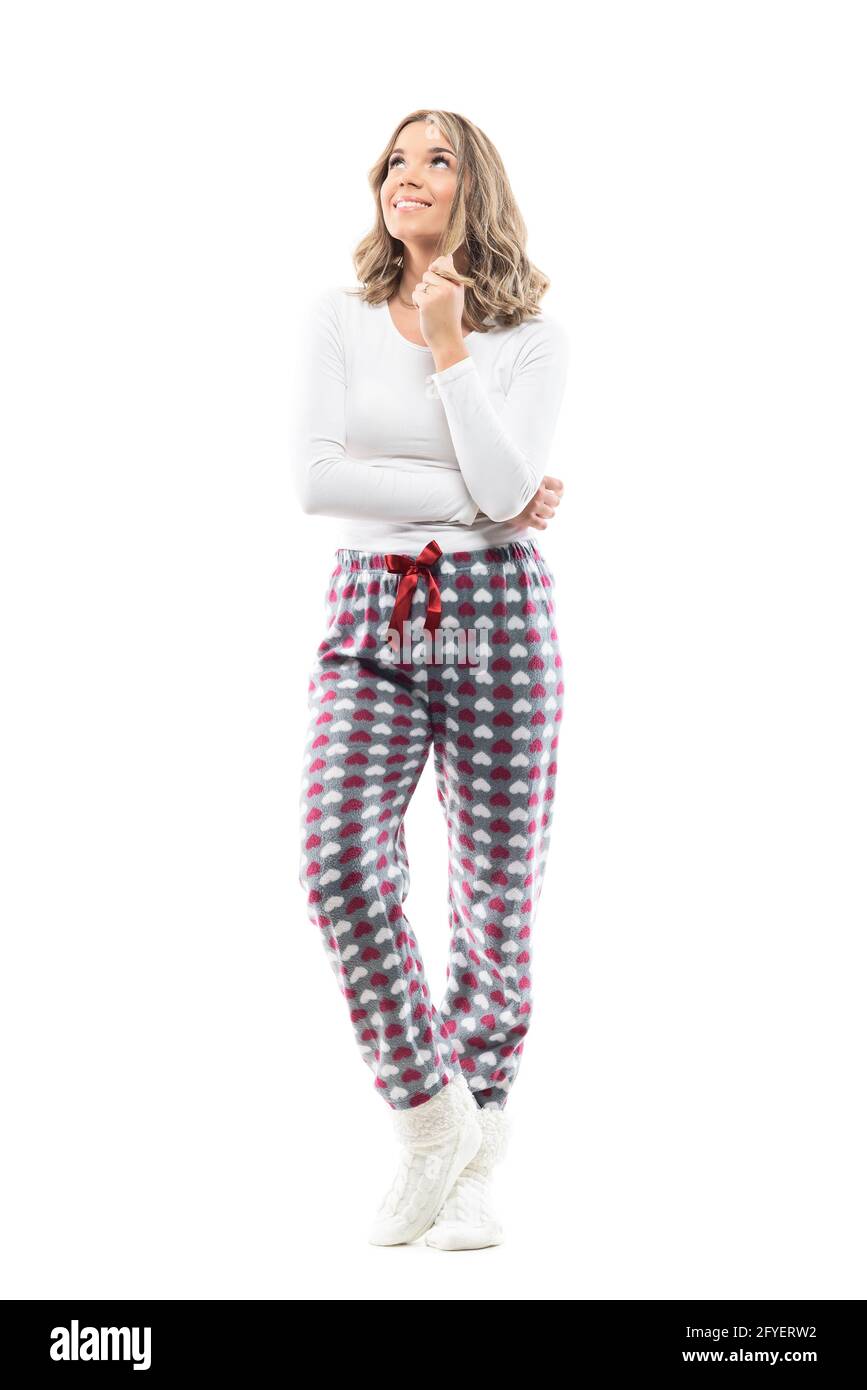 Happy woman in pajamas twisting hair making plans having idea. Full body length isolated on white background. Stock Photo