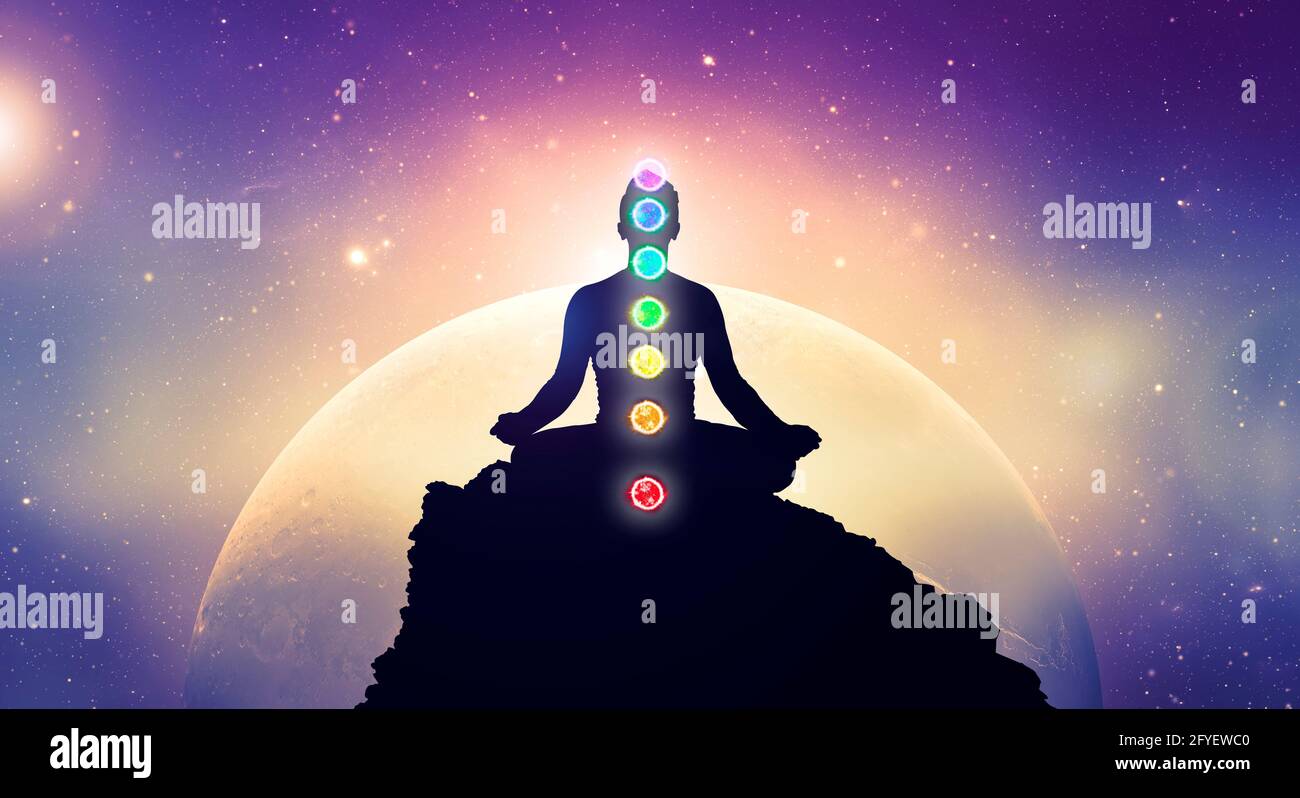 Meditating men in yoga lotus position with chakras. Mindfulness and self awereness practice. Silhiuette of meditation in space. Stock Photo