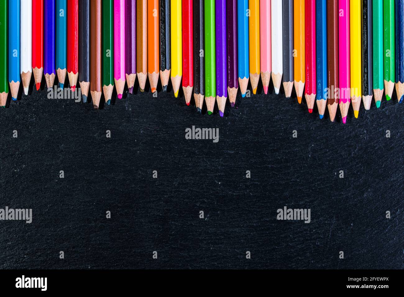 Colorful pencils frame background on black, back to school concept ...