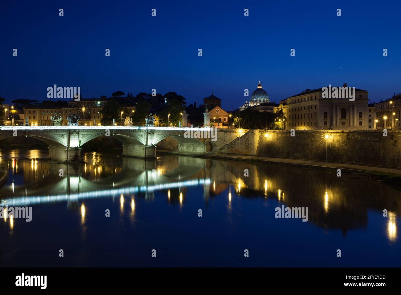 Rome at night with Ponte Vittorio Emmanuel II spanning the Tiber River and the dome of St Peter's Basilica to the right. Rome, Italy Stock Photo