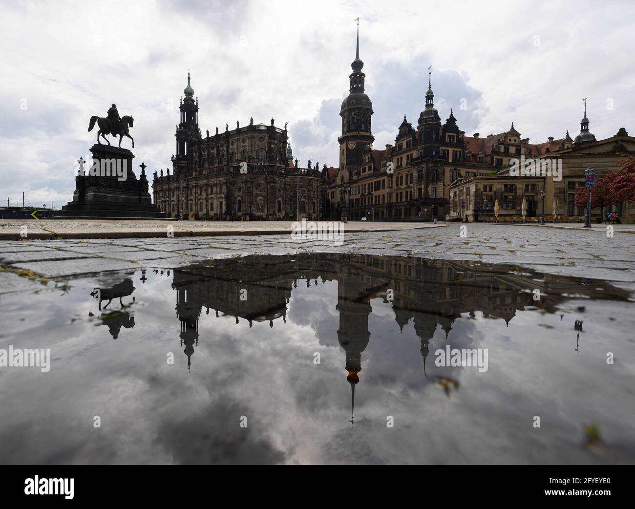 Dresden, Germany. 28th May, 2021. The equestrian statue of King Johann (l-r), the Hofkirche, the Hausmannsturm, the Residenzschloss and the Schinkelwache are reflected in a puddle on Theaterplatz in the old town. Credit: Robert Michael/dpa-Zentralbild/dpa/Alamy Live News Stock Photo