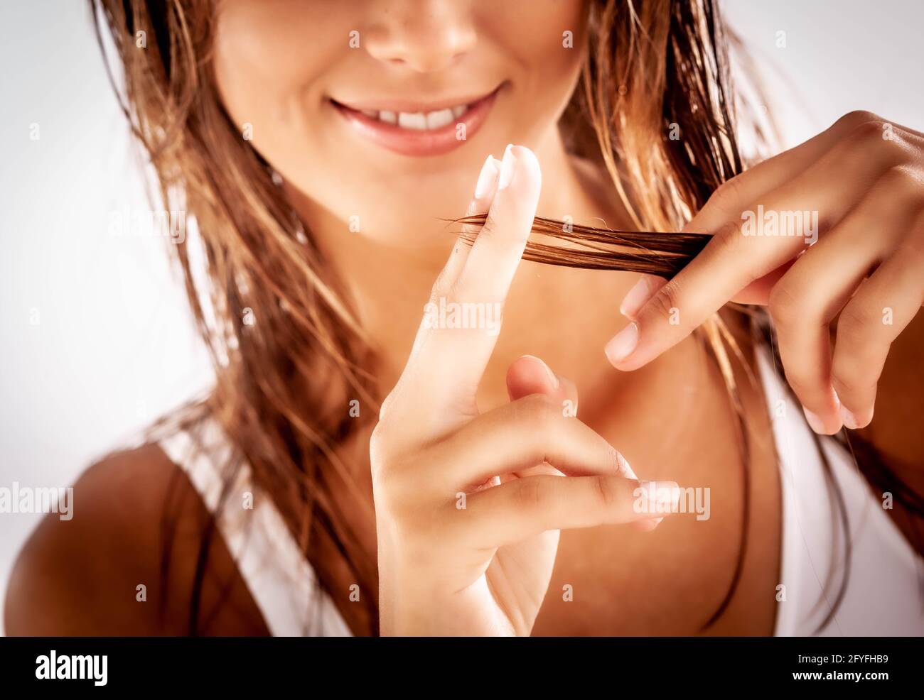 Woman inspecting the tip of her hair. Stock Photo