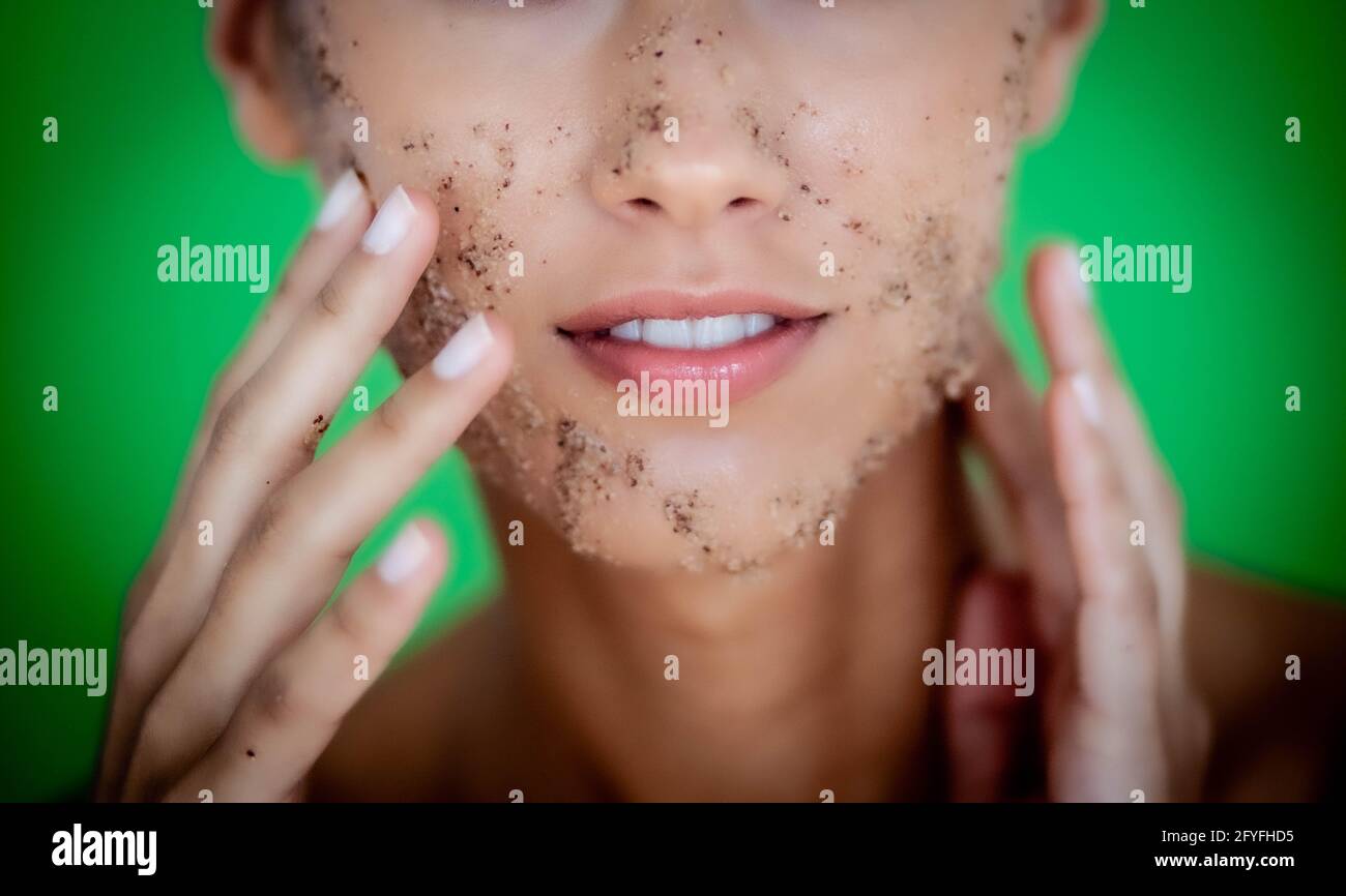 Woman exfoliating her face with facial scrub treatment. Stock Photo