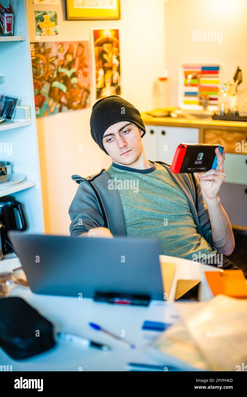 Student playing a video game on a Switch during their remote video conferencing lessons. Stock Photo