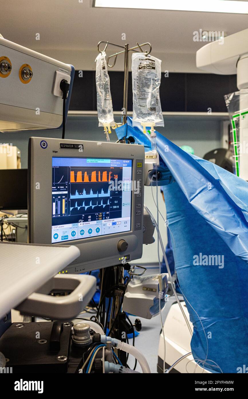 Surgical monitors being used to track the vital signs of a patient during an operation, France. Stock Photo