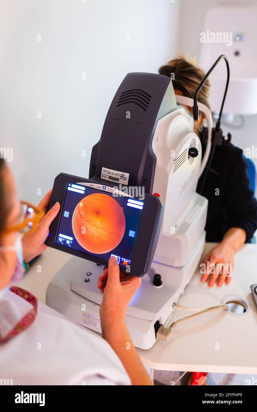 Woman doing retinography, a diagnostic test to get an image of the fundus or retina and to detect diseases that affect the retina, such as age-related Stock Photo