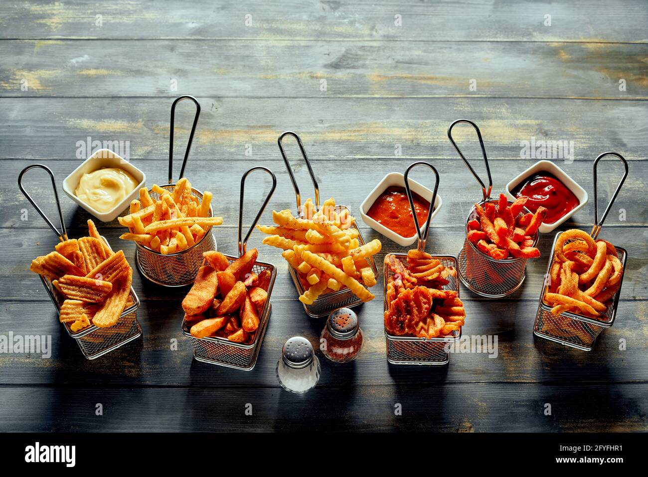 From above of appetizing fried potatoes chips waffle and crinkle fries