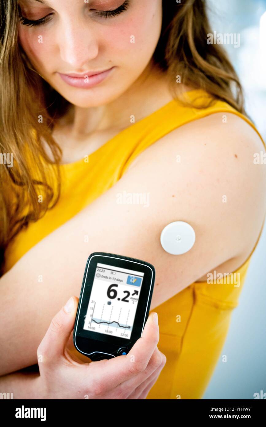 A diabetic person is checking her blood sugar level (self glycemia) with FreeStyle Libre ®. Stock Photo