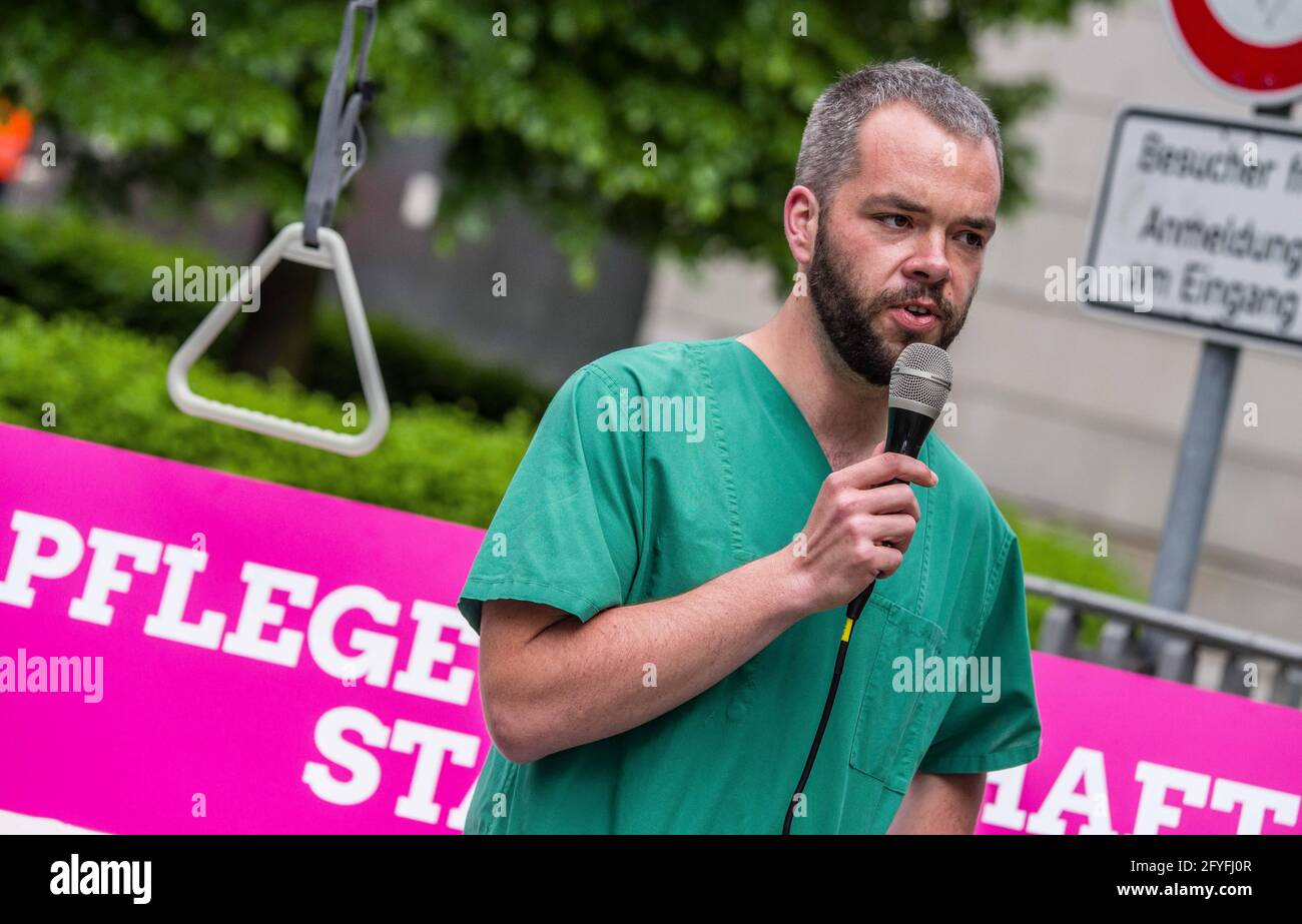 Munich, Bavaria, Germany. 28th May, 2021. ANDREAS KAHL of the Bavarian Greens wearing his hospital scrubs Kahl works in an Intensive Care Unit in Murnau and detailed the poor treatment of the healthcare workers by the Bavarian government that promotes overwork, poorer care quality, and burnout syndrome. The Bavarian Greens (die Gruenen/Buendnis90) organized a protest action at the Bavarian Staatskanzlei (government building) in support of healthcare workers. During the Coronavirus crisis, the working conditions for this sector have come into greater focus and The Greens are pushing for better Stock Photo