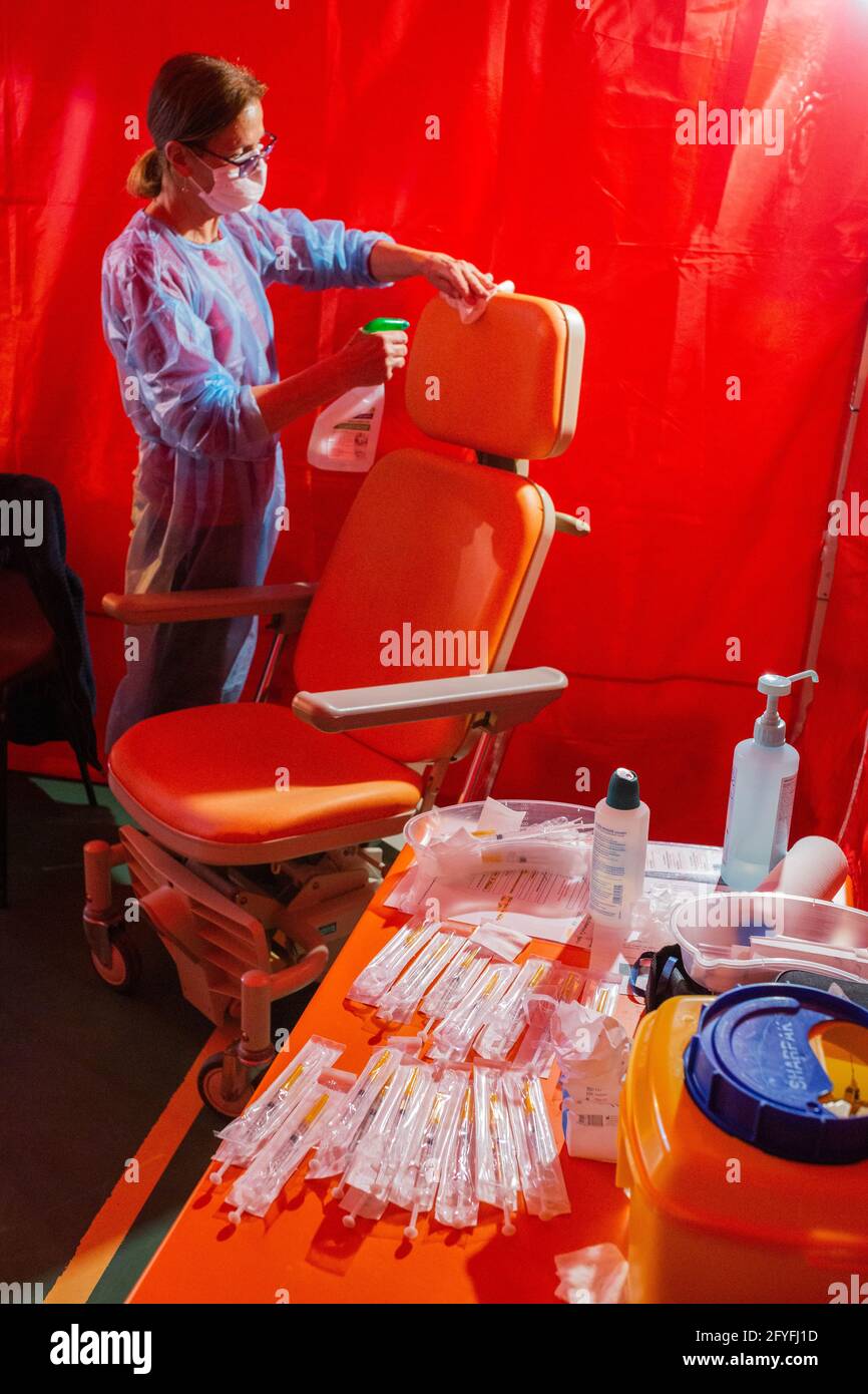 A nurse disinfects a vaccination box against Covid-19 in a municipal gymnasium transformed into a provisional vaccination center, Ribérac, April 2021. Stock Photo