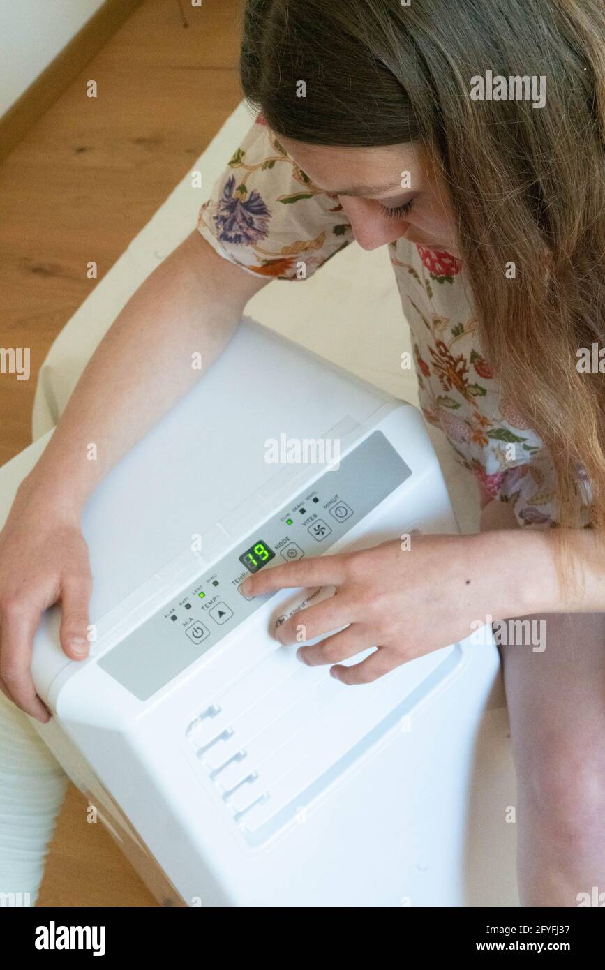 Woman using an air conditioner. Stock Photo