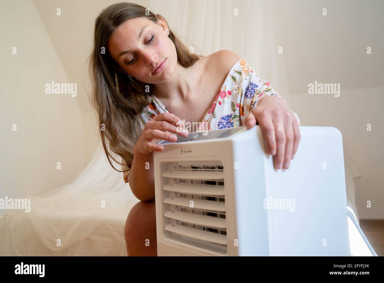 Woman using an air conditioner. Stock Photo