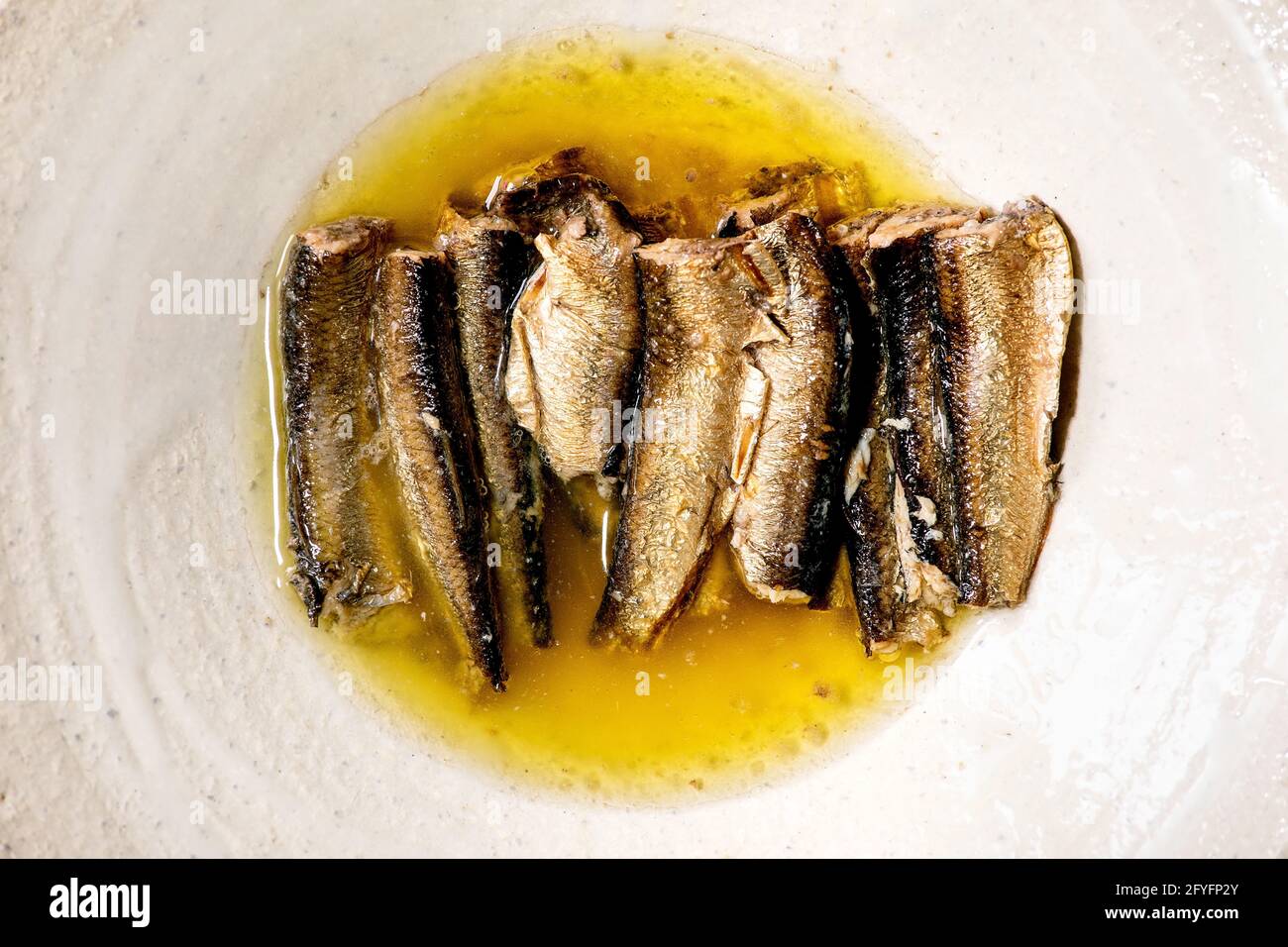 Smoked sardines in oil served in white ceramic plate . Top view, flat lay. Close up Stock Photo