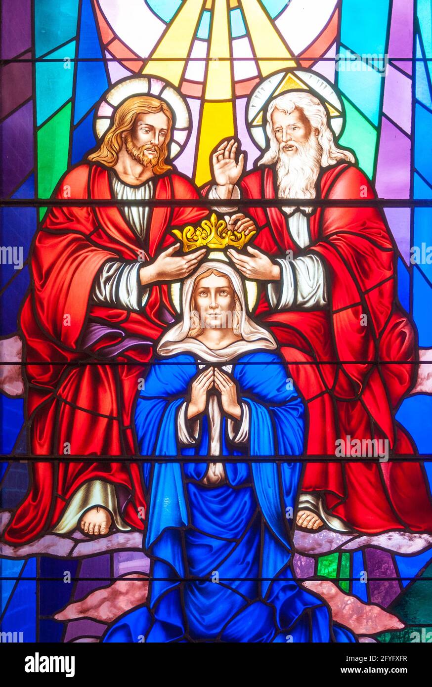 The Crowning of Mary: Christian scenes in stained glass following the catholic traditions, beautiful multicolor stained glass in a Catholic church Stock Photo