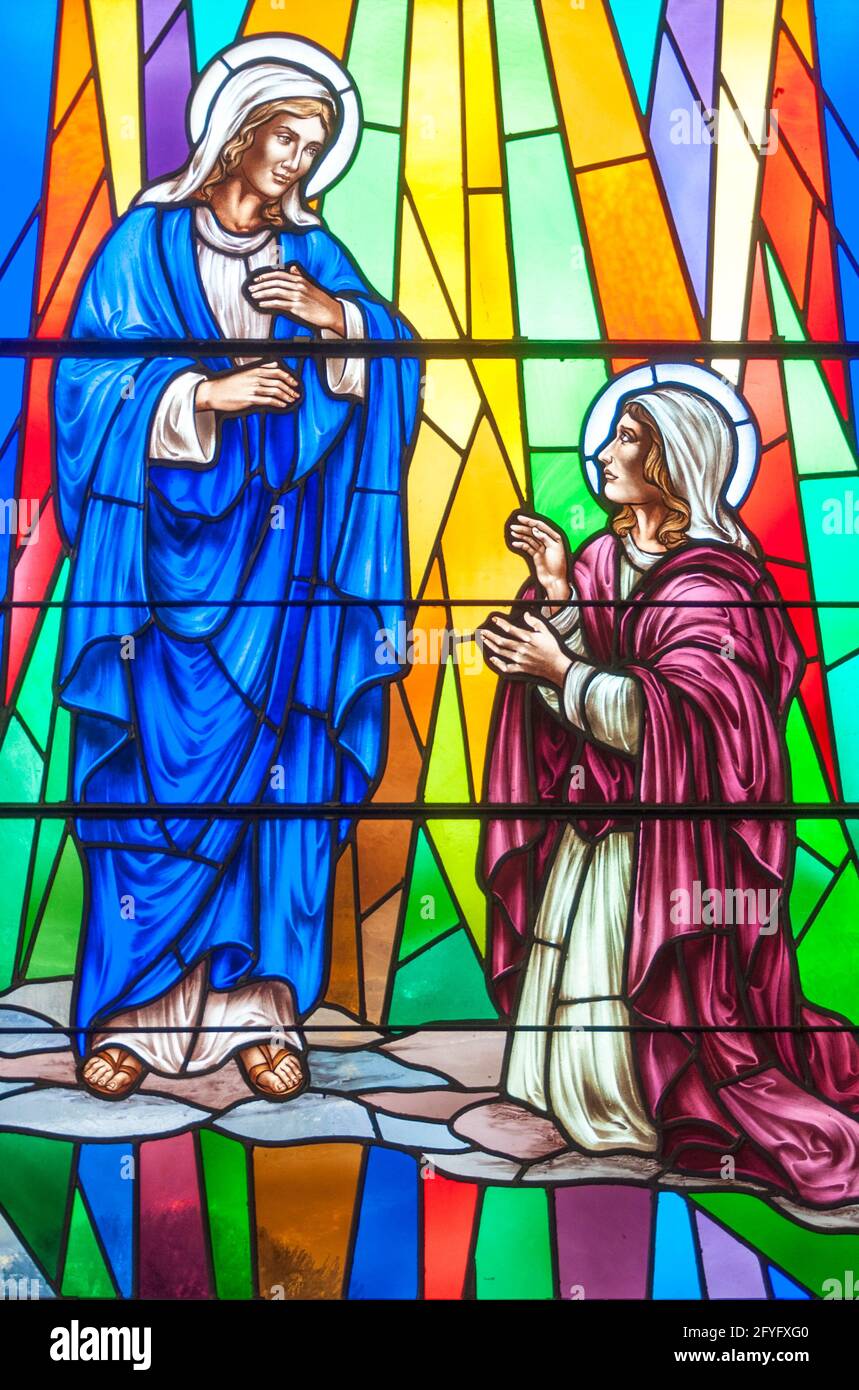Christian scenes in stained glass following the catholic traditions, beautiful multicolor stained glass in the Catholic church Stock Photo