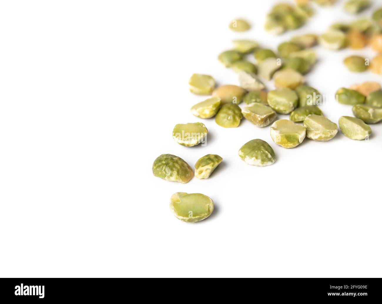 Dried green split peas, perspective view. Many half green field pea seeds randomly placed from top right to the center. Used in soups, dals, curries a Stock Photo