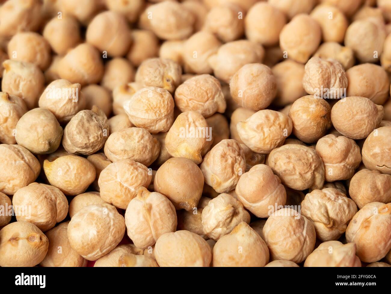 Many dry chickpeas texture. High protein superfood ingredient. Legume used as  flour or in hummus, veggie burgers and falafel. Known as garbanzo bean, Stock Photo