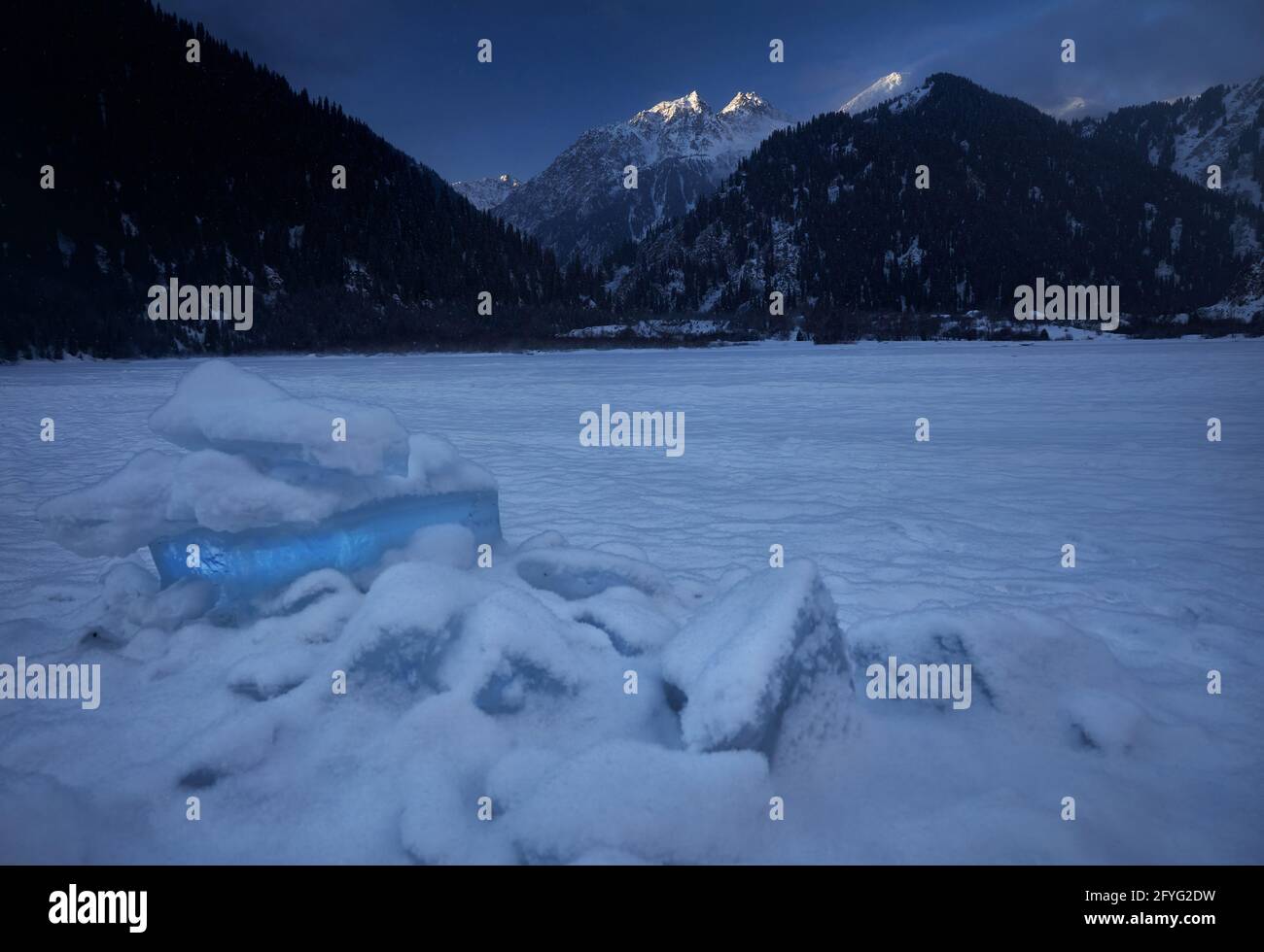Landscape of frozen mountain lake Issyk with big ice formations at winter time at sunrise in Kazakhstan Stock Photo