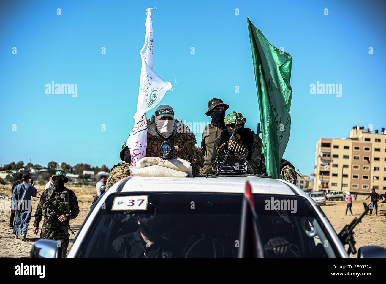 Gaza, Palestine. 27th May, 2021. Masked members of the Izz al-Din al-Qassam Brigades, the military wing of Hamas drive in cars while carrying heavy weapons during a military parade on the Streets in Khan Yunis, southern Gaza Strip. (Photo by Yousef Masoud/SOPA Images/Sipa USA) Credit: Sipa USA/Alamy Live News Stock Photo