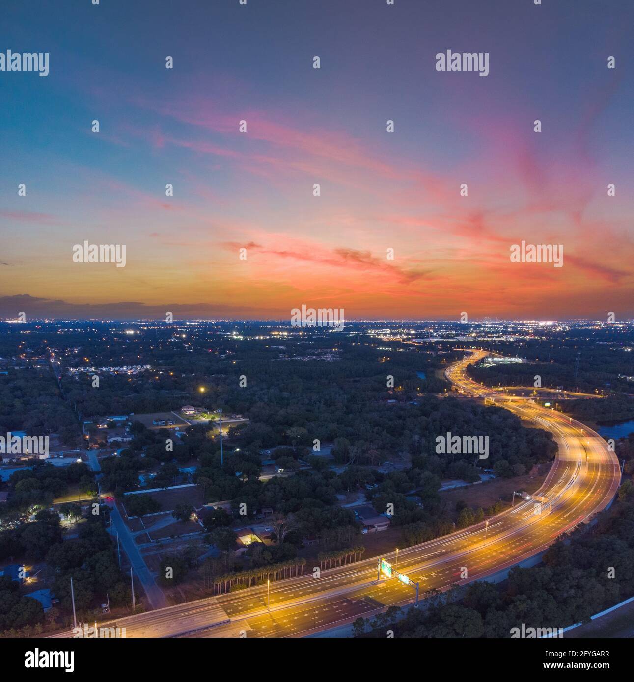 Beautiful long exposure sunset taken at dusk in Tampa, Florida with amazing clouds, car light trails on the highway, and pastel colors. Stock Photo