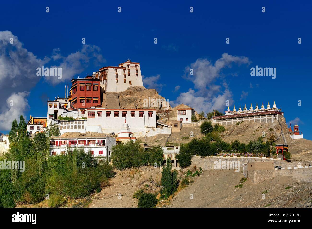 Thiksay monastery with view of Himalayan mountians and blue sky with white clouds  in background,Ladakh,Jammu and Kashmir, India Stock Photo
