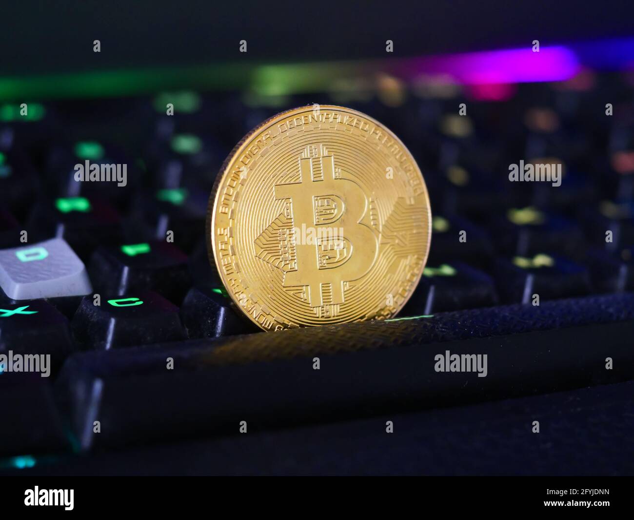 Closeup of a bitcoin cryptocurrency put on a gaming RGB keyboard Stock ...
